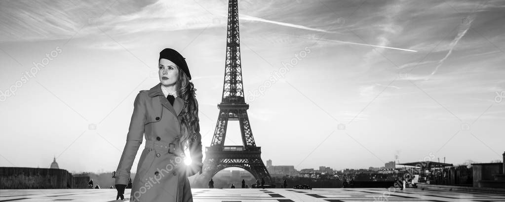 Bright in Paris. Full length portrait of modern traveller woman in red coat against Eiffel tower in Paris, France looking into the distance