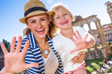 Roma tatili. şık Anne ve kızı gezginler Roman Forum önünde Roma, İtalya, handwaving ile gülümseyen
