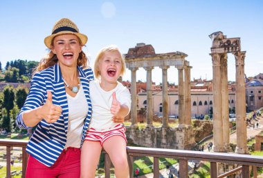 Roma tatili. Modern anne ve çocuk turistler önünde Roman Forum Roma, İtalya başparmak gösterilmesini gülümseyen