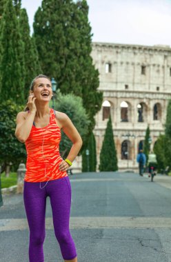 Gladyatör eğitimler ilham verici. mutlu genç fitness kadın spor giysileri yakınındaki müzik Kolezyum Roma, İtalya