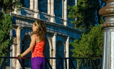 Gladyatör eğitimler ilham verici. Roma, İtalya müzik Colosseum yakınındaki spor viteste modern sağlıklı kadın arkasından gördüm