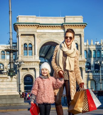 Tam uzunlukta portresi mutlu zarif anne ve kızı seyahat etmek ile alışveriş torbaları yakınındaki Galleria Vittorio Emanuele II, Milano, İtalya
