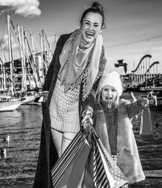 Zarif anne ve çocuk alışveriş torbaları üzerinde dolgu Barcelona, İspanya ile gülümseyen tam uzunlukta portresi