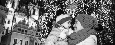 Sihirli Noel tarihi kentin sokaklarında. Genç Anne ve çocuk turistler Noel'de birbirine bakarak Prag Çek Cumhuriyeti'nde Staromestske namesti üzerinde gülümseyen