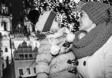Sihirli Noel tarihi kentin sokaklarında. mutlu modern anne ve kızı turist Noel birbirine bakarak Prag Çek Cumhuriyeti