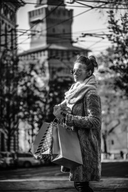 mesafe içine arıyorum genç kadınla alışveriş torbaları ve Noel hediyesi yakınındaki Sforza Kalesi, Milano, İtalya