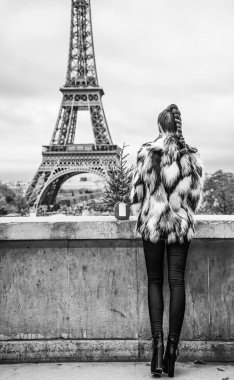 Noel ağacı Paris, Fransa'da Eyfel Kulesi önünde kürk paltolu trendy kadınla arkasından gördüm