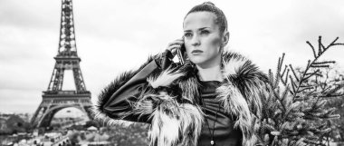 modern kadın cep telefonundan söz ile Noel ağacı kürk ceket Paris, Fransa