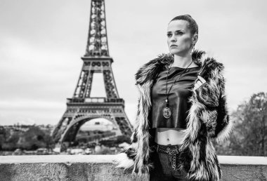 mesafe içine bakarak kürk manto Paris, Fransa'da Eyfel Kulesi önünde trendy kadında