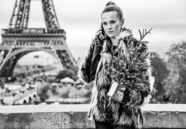 kürk manto Eyfel Kulesi Paris, Fransa bir cep telefonuyla konuşurken karşı Noel ağacı ile modern moda sökücü