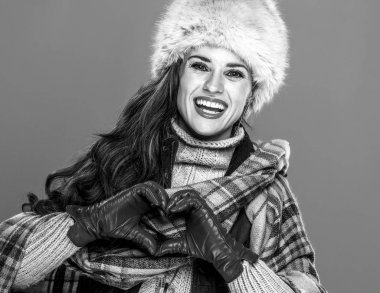 Kış şeyler. Gülümseyen kalp gösterilen Kürk şapkalı modern kadın portresi el şeklinde