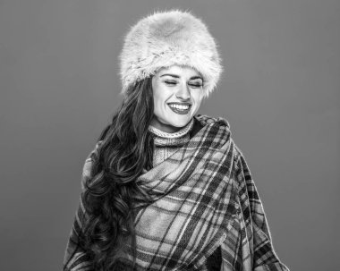 Kış şeyler. Kürk şapka soğuk mavi gülüyor üzerinde izole mutlu genç kadın portresi