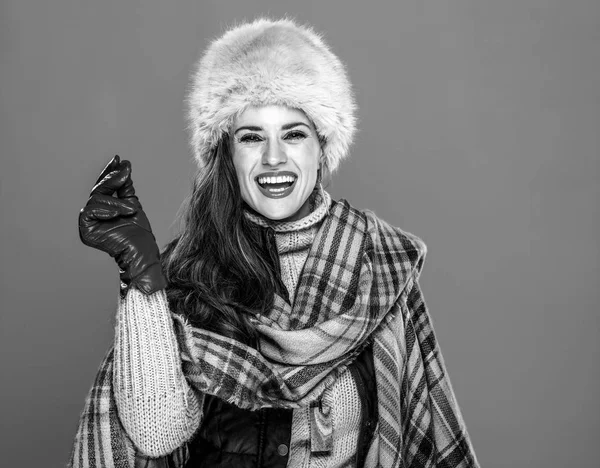 冬の事 毛皮の帽子の指のスナップで笑顔のトレンディな女性の肖像画 — ストック写真