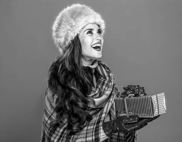 冬の事 毛皮の帽子のプレゼント ボックスを与えることで幸せなトレンディな女性の肖像画 — ストック写真