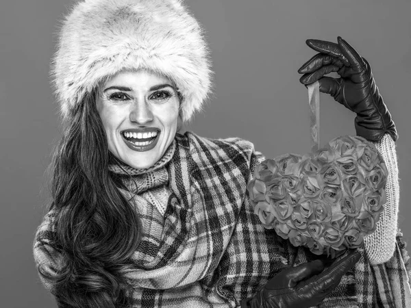 Kış şeyler. kürk şapka kırmızı kalp tutan mutlu modern kadın