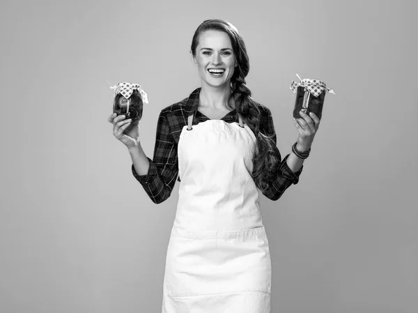 幸福的现代妇女的肖像厨师穿着围裙 展示了一罐腌制的蔬菜和蘑菇 — 图库照片