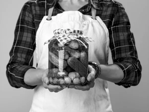 现代女农民戴围裙展示一罐腌黄瓜特写 — 图库照片