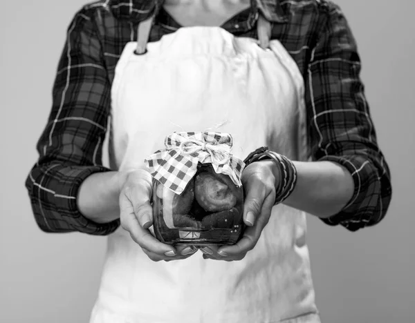 现代女性厨师戴围裙的特写显示一罐腌蘑菇 — 图库照片