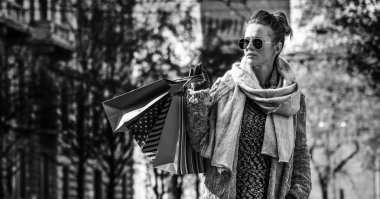 Tam uzunlukta portresi genç gezgin kadınla mesafe içine bakarak alışveriş torbaları, Milano, İtalya