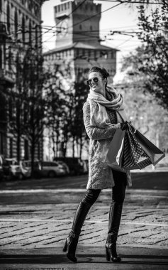 Gülümseyen mesafe içine bakarak zarif gezgin kadın alışveriş torbaları, Milano, İtalya ile tam uzunlukta portresi