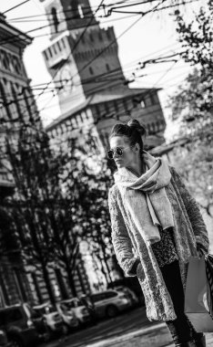 trendy kadınla mesafe içine bakarak alışveriş torbaları yakınındaki Sforza Kalesi, Milano, İtalya