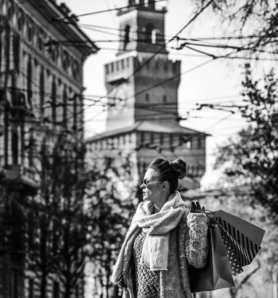 mesafe içine arayan trendy seyahat kadın kürk manto ve güneş gözlüğü, Milano, İtalya