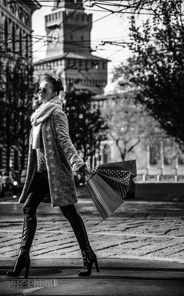 Milan, İtalya, yürüyüş alışveriş torbaları ile genç kadın portresi tam uzunlukta