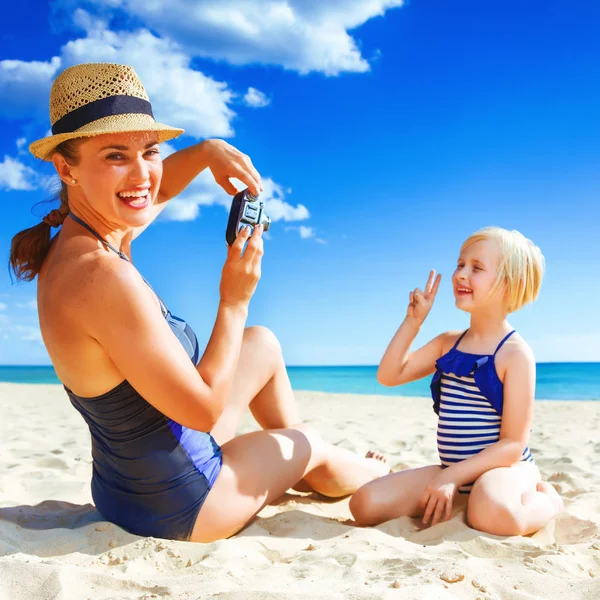 太陽に輝く美しさ レトロなカメラ撮影と海岸のビーチウェアで幸せな健康的な母と娘 — ストック写真