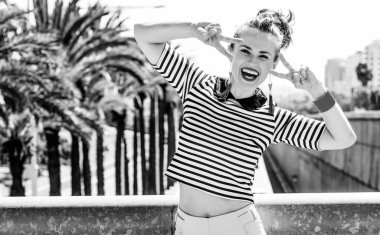 Nosing çevresinde, eğleniyor. Trendy kadın şort ve Otoban şehrin mesafe içine bakarak karşı çizgili gömlek gülümseyen