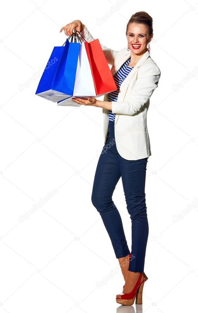 Luxury Shopping. The French way. Full length portrait of happy trendy woman in white jacket isolated on white showing shopping bags painted in the color of the French flag