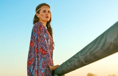 Bohem vibe tatil. Trendy özgür ruhlu kız açık havada mesafe içine arıyorum yaz akşam pelerinli tam uzunlukta portresi