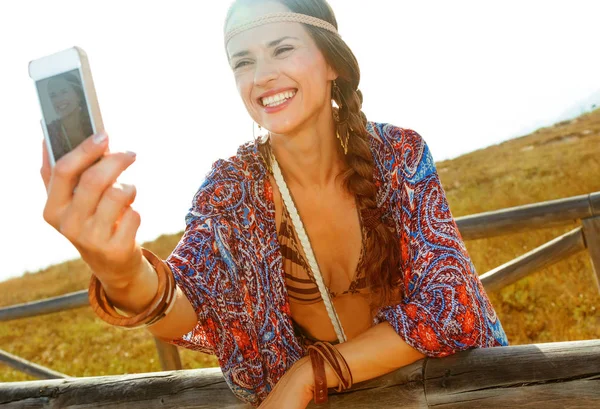 自由奔放な雰囲気のバカンス Selfie を取ってスマート フォンで夏の夜に屋外で幸せな自由奔放に生きる少女 — ストック写真