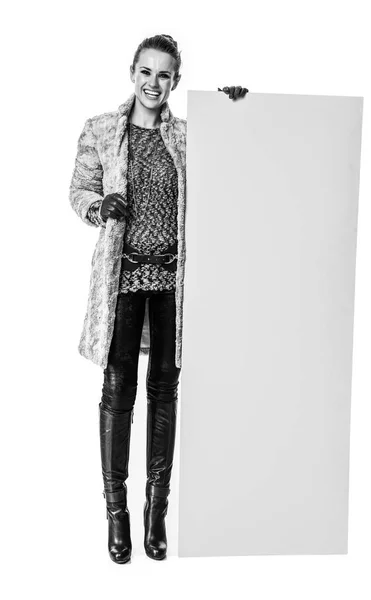 冬の事 空白ボードを示す白で隔離の冬のコートで幸せなトレンディな女性の完全な長さの肖像画 — ストック写真