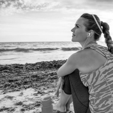 Mavi deniz, beyaz kum cenneti. Tam uzunlukta mesafe içine arayan sahil üzerinde parlak mayo mutlu modern kadın portresi