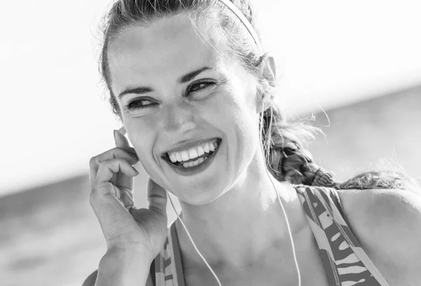 清新的野海边锻炼 快乐健康适合的妇女在海岸运动衫与耳机听音乐 — 图库照片