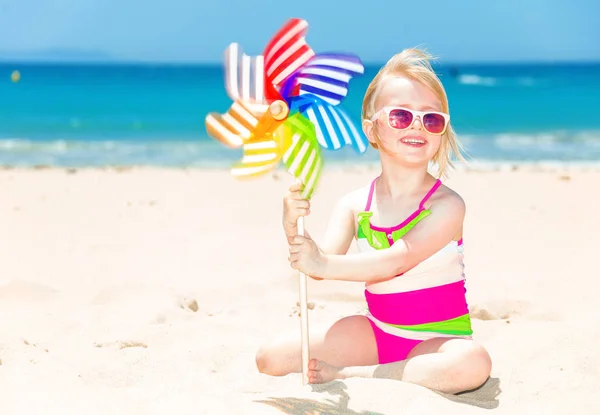 Renkli Yel Değirmeni Oyuncak Ile Sahil Üzerinde Renkli Mayo Mutlu — Stok fotoğraf