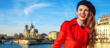 Paris'te parlak. mutlu genç turist kadın kırmızı trençkot üzerinde dolgu yakın mesafe içine bakarak Notre Dame de Paris Paris, Fransa