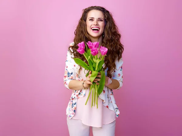 粉红色的心情 快乐时尚的女人与长的波浪状黑发黑头发被隔离粉红色与花束的郁金香 — 图库照片