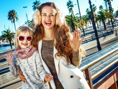 Modern anne ve kızı gezginler Barselona, İspanya, handwaving içinde gülümseyen