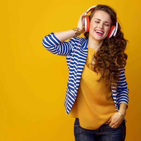 Kulaklıklarla Müzik Moda Sarı Arka Plana Karşı Uzun Dalgalı Esmer — Stok fotoğraf