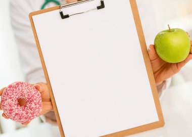 yukarı gösteren boş Pano elma ve donut tıp doktoru kadını