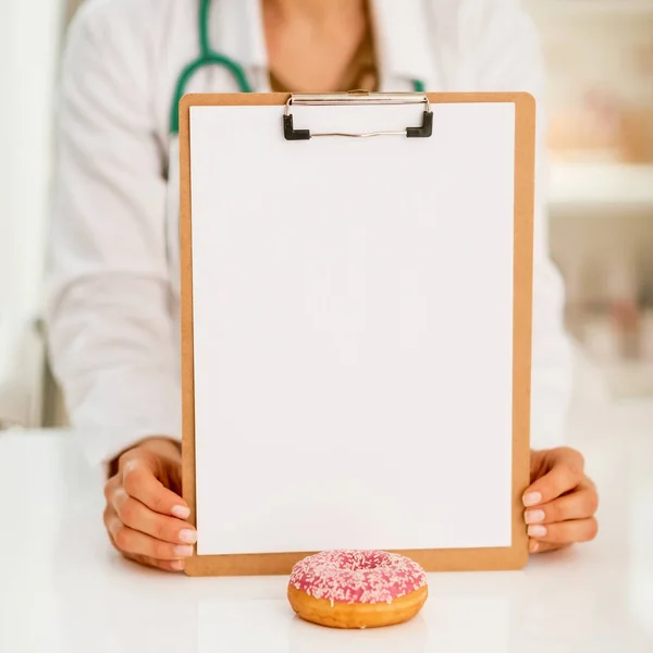 Close Médico Mulher Mostrando Prancheta Donut — Fotografia de Stock