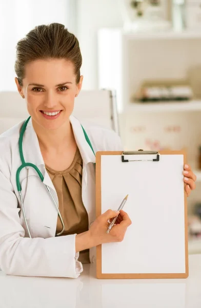 クリップボードで指している幸せな医師の女性 — ストック写真