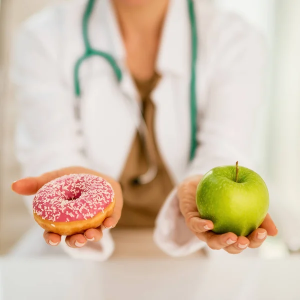 Close Médico Mulher Dando Uma Escolha Entre Maçã Donut — Fotografia de Stock