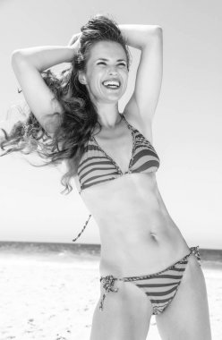 Mavi deniz, beyaz kum cenneti. gülümseyen bikini mesafe içine arayan sahil üzerinde uzun esmer saçlı Genç kadın