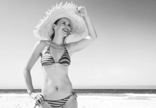 白沙乐园 微笑的现代妇女在海滩和草帽在海岸看入距离 — 图库照片