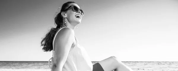 Улыбающаяся Современная Женщина Солнечных Очках Красочное Платье Берегу Моря Глядя — стоковое фото
