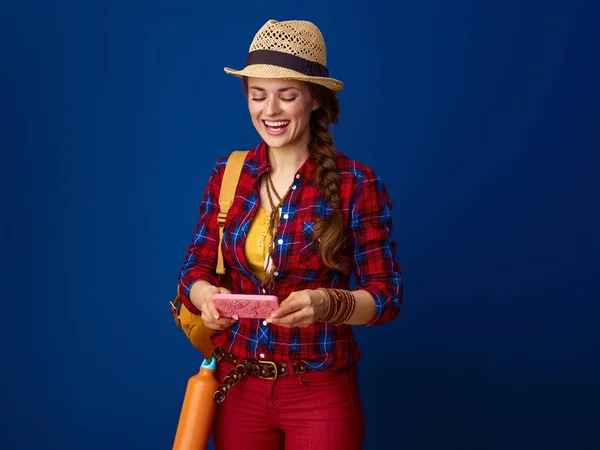 Usmívající Žena Aktivní Cestovatel Kostkované Košili Psaní Sms Modrém Pozadí — Stock fotografie