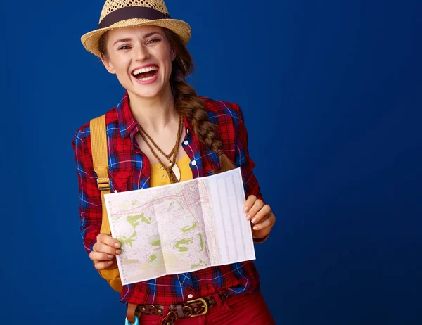 青色の背景の地図とバックパックで旅行者の女性に合う笑顔 — ストック写真