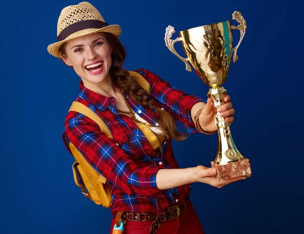 Щаслива Активна Мандрівна Жінка Плетеній Сорочці Показує Кубок Синьому Фоні — стокове фото